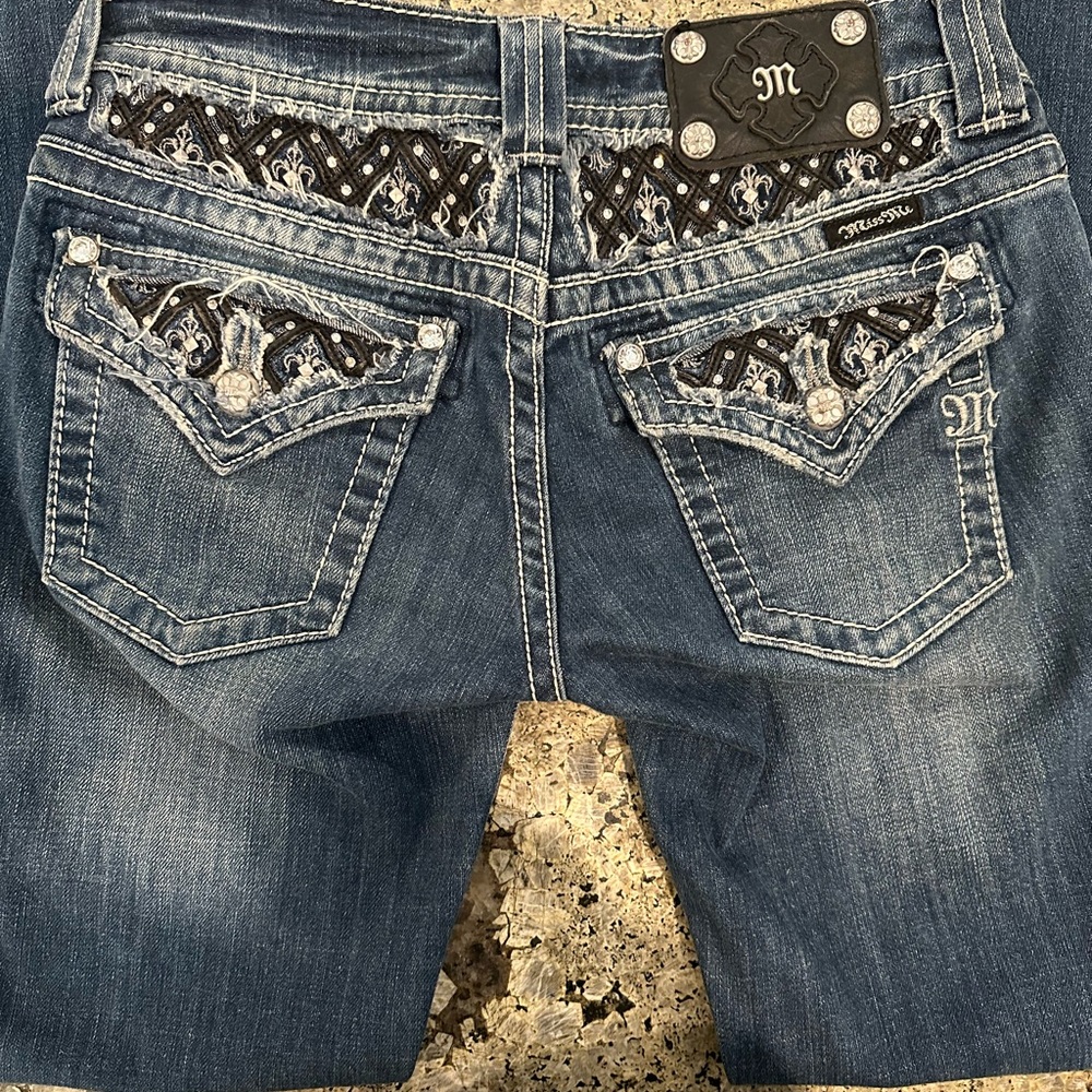 Miss Me Jeans. Black silver and rhinestone accents on back and front.